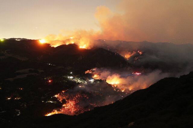 Flames and smoke from the Palisades Fire engulf parts of the community of Topanga, Califor
