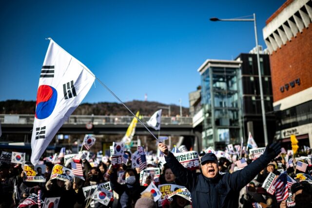 People wave US and South Korean flags at a rally to support impeached South Korea Presiden