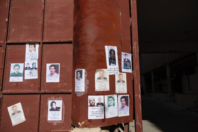 Pictures of missing people hang on the main gate of Syria's Saydnaya prison, which epitomi