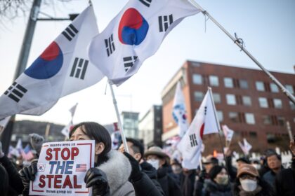 A protester holds a placard reading "Stop the Steal" during a rally to support impeached S