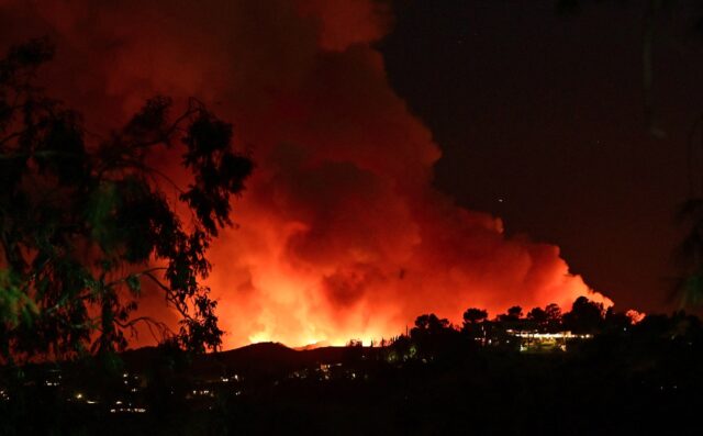 Smoke and flames from the Palisades Fire burn toward the Encino neighborhood of Los Angele