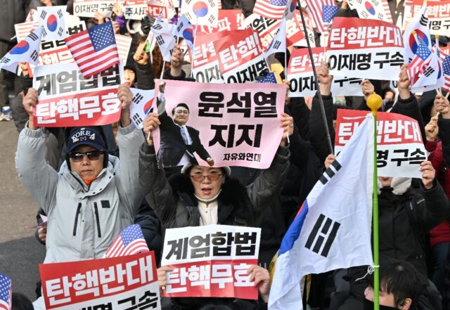 Supporters of impeached South Korean President Yoon Suk Yeol hold placards during a prote