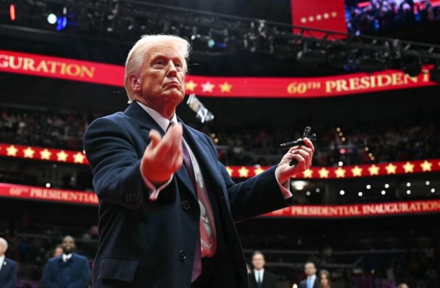 US President Donald Trump throws pens to the crowd after signing executive orders during h