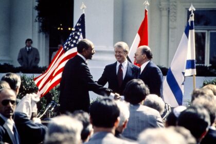 US President Jimmy Carter (C) congratulates Egyptian President Anwar al-Sadat (L) and Isra