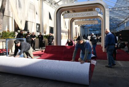 Workers unroll the red carpet ahead of the Golden Globes