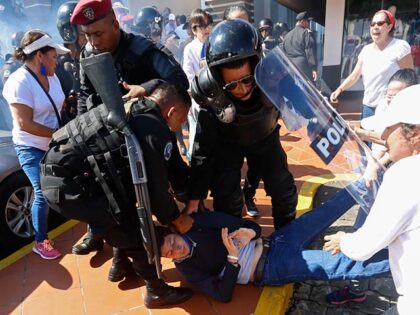 An anti-government protester is detained by police as security forces disrupt an oppositio