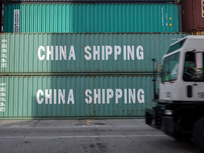 A jockey truck passes a stack of 40-foot China Shipping containers, July 5, 2018, at the P