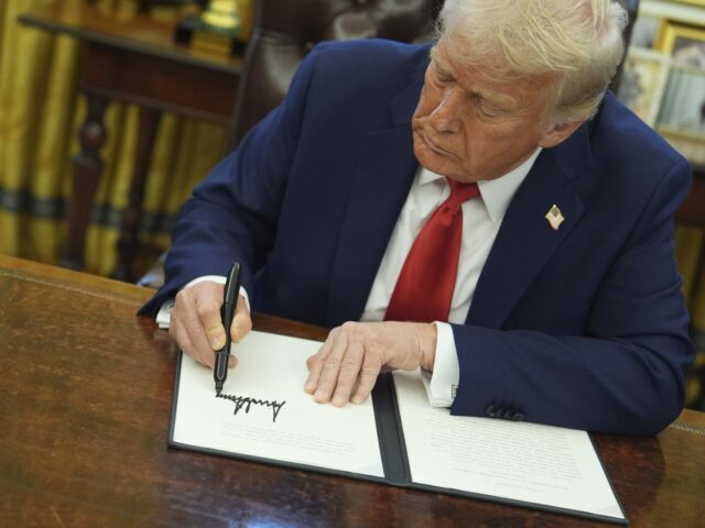 President Donald Trump signs an executive order in the Oval Office of the White House, Mon