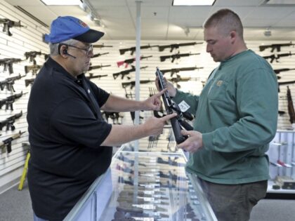 Roger Krahl, president of R Guns, left, gives information to Zack Johnson about an R Guns-