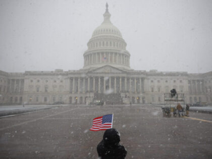 WASHINGTON, DC - JANUARY 19: An American flag is held in the snow outside the U.S. Capitol