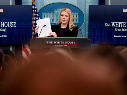 White House Press Secretary Karoline Leavitt holds up a document as she reads off line ite