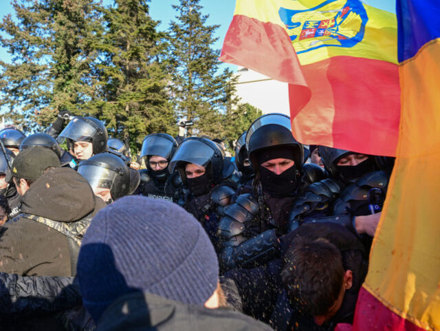 Romanian gendarmes use pepper spray to block protesters who force the protection barrier i