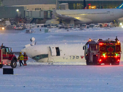 A Delta airlines plane sits on its roof after crashing upon landing at Toronto Pearson Air