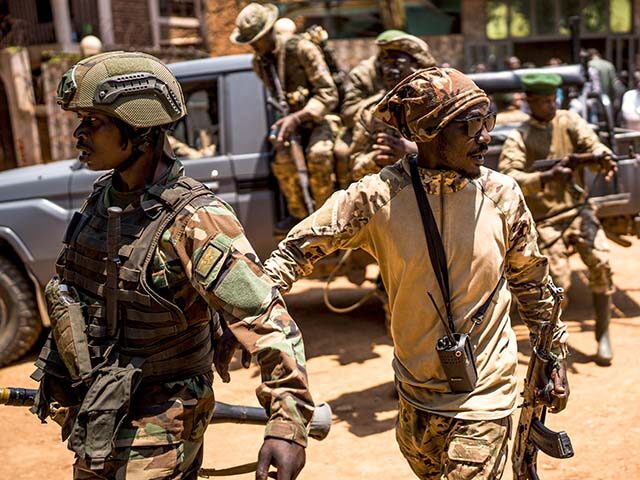 M23 rebels guard a unit of surrendering Congolese police officers who will be recruited in