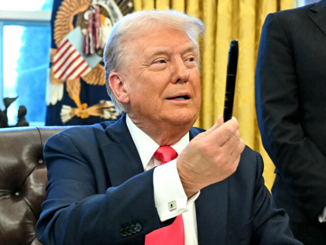 US President Donald Trump holds a sharpie after signing an Executive Order at the Oval Off