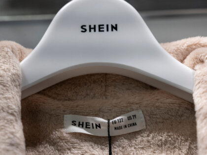 This photo taken on November 10, 2022 shows the Shein logo on a coat hanger and label duri