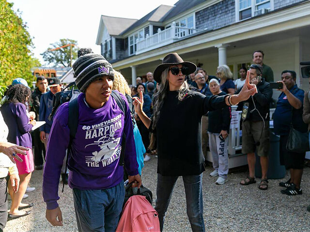 A Venezuelan migrant is led onto a bus at St. Andrews Episcopal Church on Friday, Sept. 16