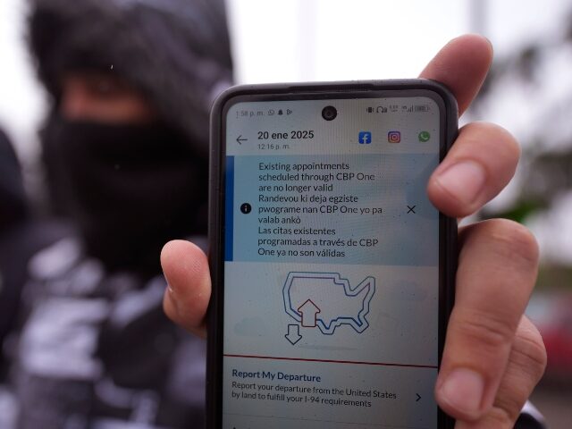 A migrant seeking asylum holds up the CBP One app showing his appointment was canceled aft