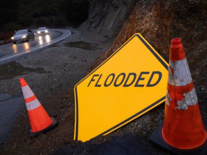 ALTADENA, CALIFORNIA - FEBRUARY 14: A sign warning of flooding stands next to the Angeles