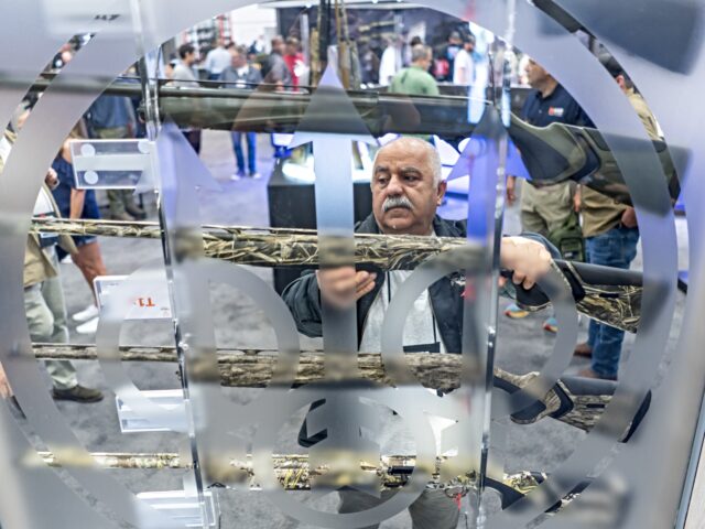 An attendee examines shotguns during the National Rifle Association (NRA) annual conventio