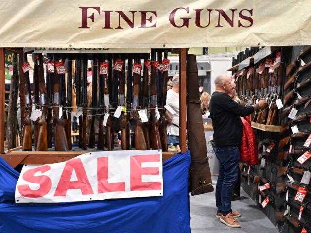 guns for sale BIRMINGHAM, ENGLAND - FEBRUARY 23: Visitors view shotguns at a discount sale during The Br