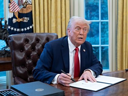 US President Donald Trump signs an executive order during a ceremony in the Oval Office of