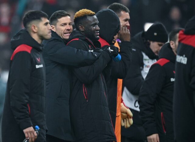 Bayer Leverkusen coach Xabi Alonso embraces striker Victor Boniface after he scored the wi