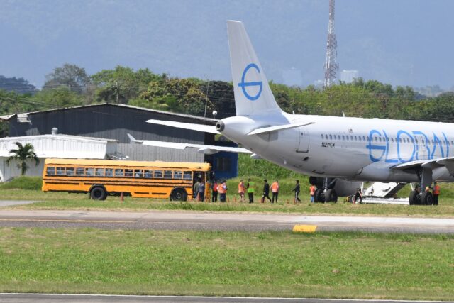 Brazilian migrants deported from the United States walk to board a bus upon arrival at the