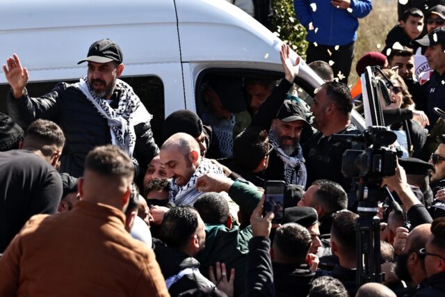 A cheering crowd hoisted freed Palestinian prisoners onto their shoulders after they arriv