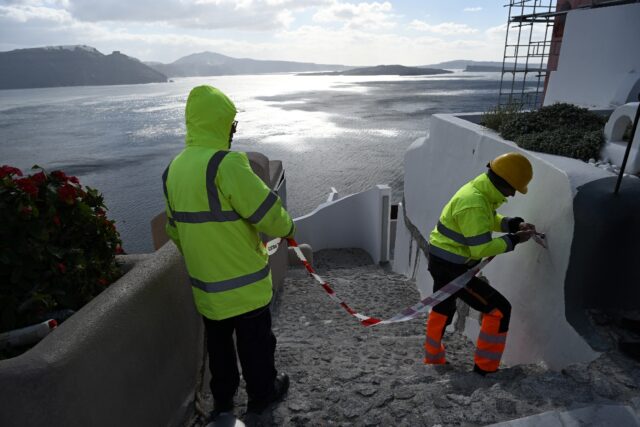 Council workers restrict access to the village of Oia on Santorini