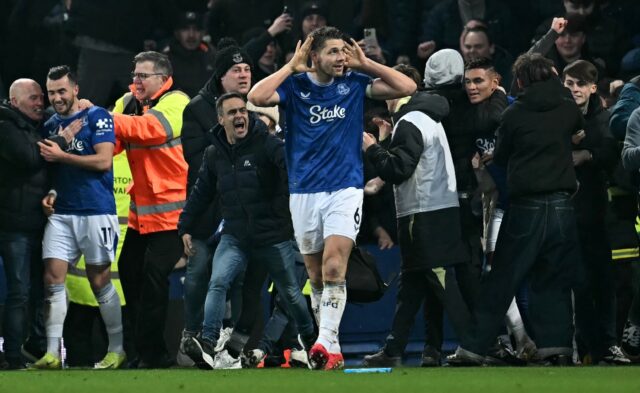 Late, late show: James Tarkowski is mobbed by fans as he celebrates scoring Everton's seco