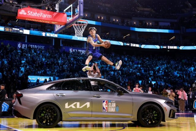 Mac McClung dunks the ball while jumping over a car on his way to winning the NBA Slam Dun