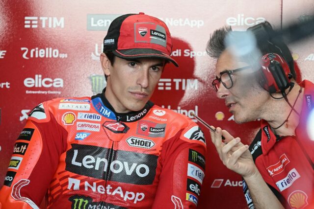 Marc Marquez (L) consults with a Ducati team member at Buriram