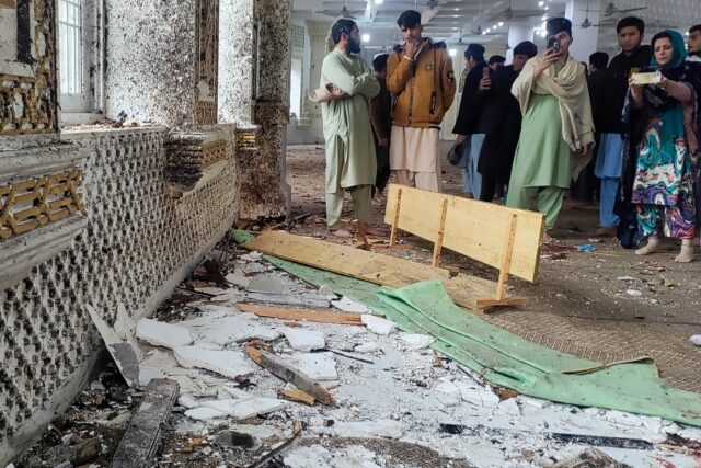 Onlookers gather after a suicide blast during Friday prayers at Dar-ul-Uloom Haqqania scho
