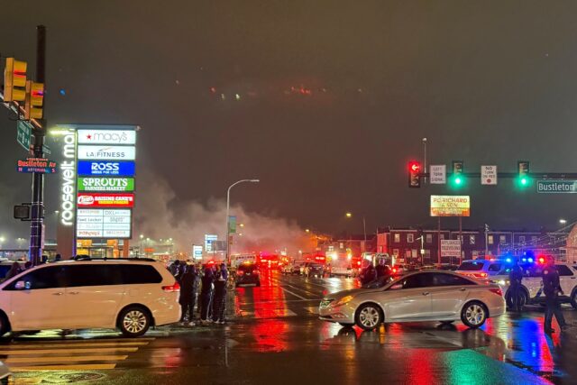 A plume of smoke and emergency responders can be seen after a small aircraft crashed in a