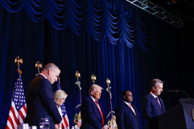 US President Donald Trump (C) bows his head during the National Prayer Breakfast at the Wa