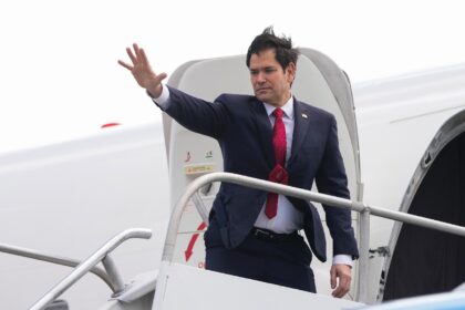 US Secretary of State Marco Rubio waves as he boards a plane bound to Guatemala at Juan Sa