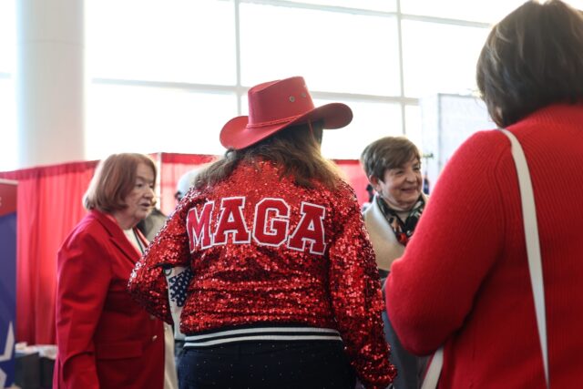 A woman wears a 'MAGA' jacket displaying her support for President Donald Trump at a major