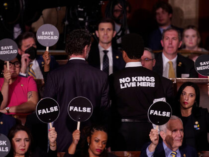 House Democrats hold signs in protest during a joint session of Congress in the House Cham