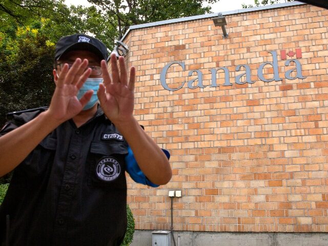 AP20219345882165 A security officer wearing a face mask to help protect against the coronavirus gestures ou