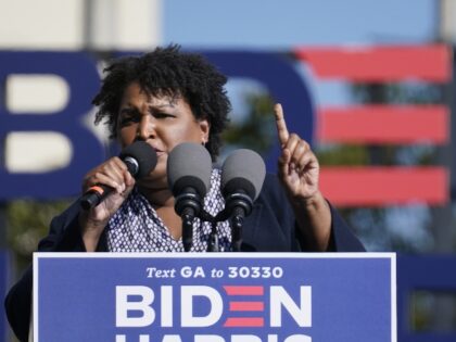 Stacey Abrams speaks to Biden supporters as they wait for former President Barack Obama to