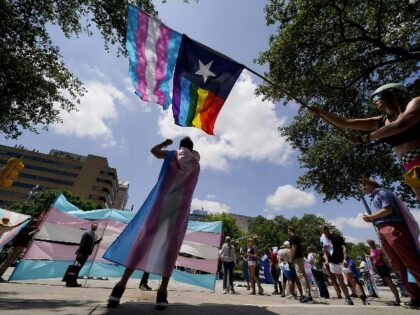 FILE - Demonstrators gather on the steps to the State Capitol to speak against transgender