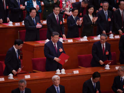 Chinese President Xi Jinping, center, smiles during the closing session of the National Pe