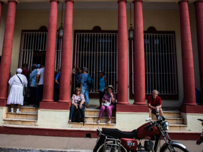 People await outside the Banco de Crédito y Comercio (Bank) in Trinidad, Cuba, on January