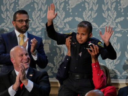 Devarjay "DJ" Daniel waves as FBI director Kash Patel and Jeff Denard of Decatur