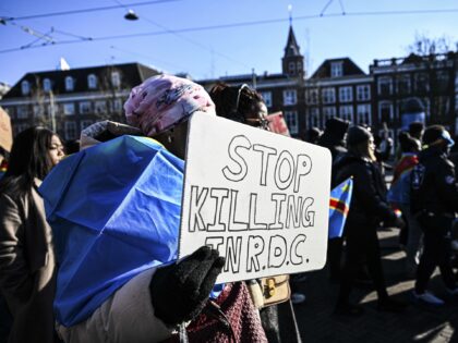 A demonstrator carries a sign among the crowd, demanding justice as protesters march towar