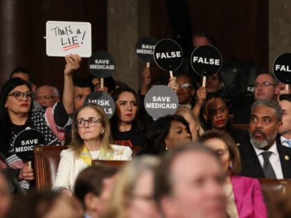 Democrats hold protest signs US President Donald Trump speaks during an address to a joint