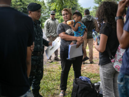 U.S. immigration agents supervise as a Guatemalan border policeman speaks with an immigran