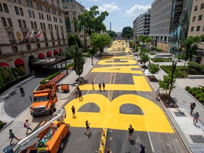 People walk down 16th street after volunteers, with permission from the city, painted "Bla