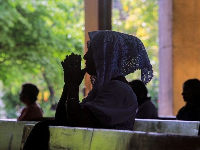 A woman prays during a mass given by Nicaraguan Cardinal Leopoldo Brenes (out of frame) at